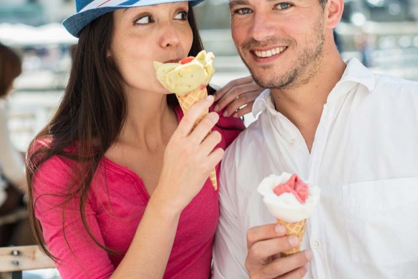 Portrait of a smiling couple eating ice cream in the city.